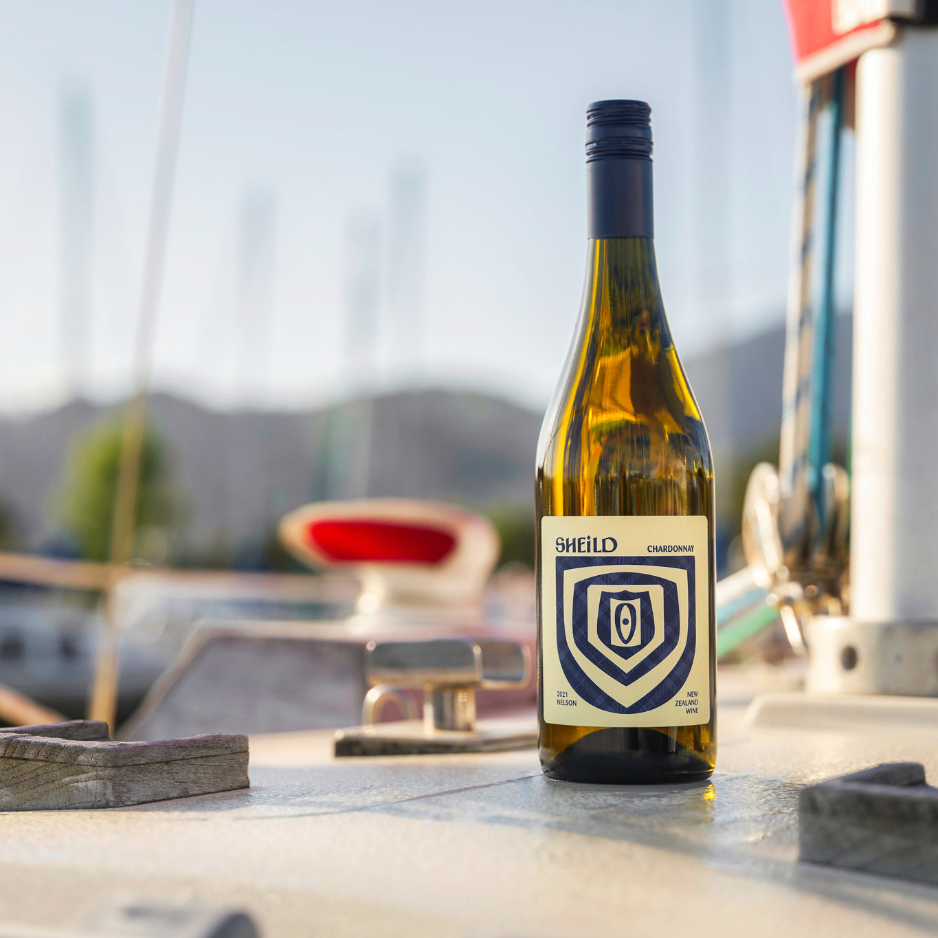 SHEiLD's Chardonnay wine placed on a marina jetty on a sunny day.