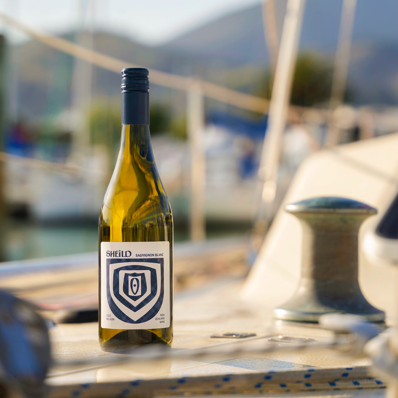 SHEiLD's Sauvignon Blanc wine placed on a marina jetty on a sunny day.