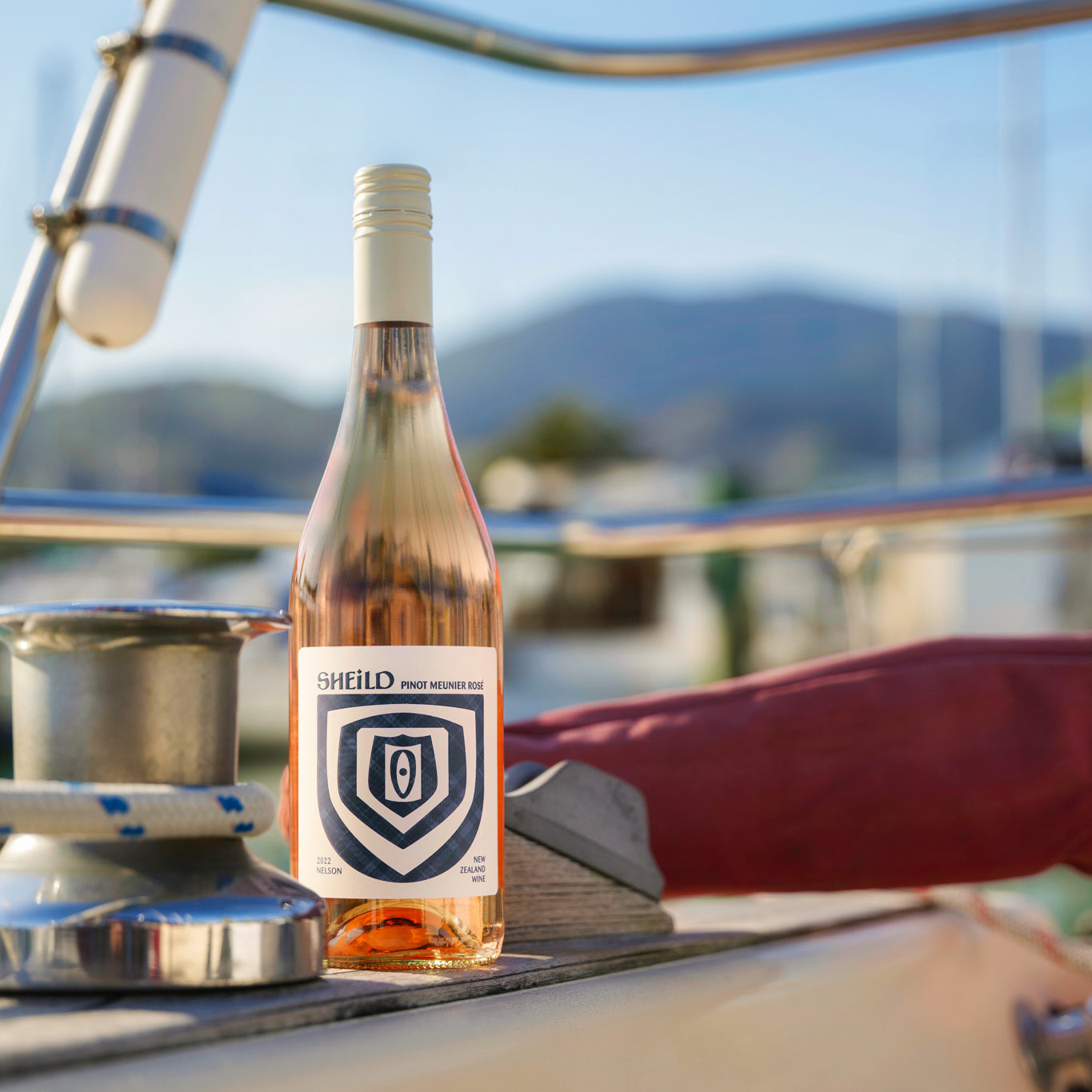 SHEiLD's Pinot Meunier Rosé wine next to a marina mooring on a sunny day.